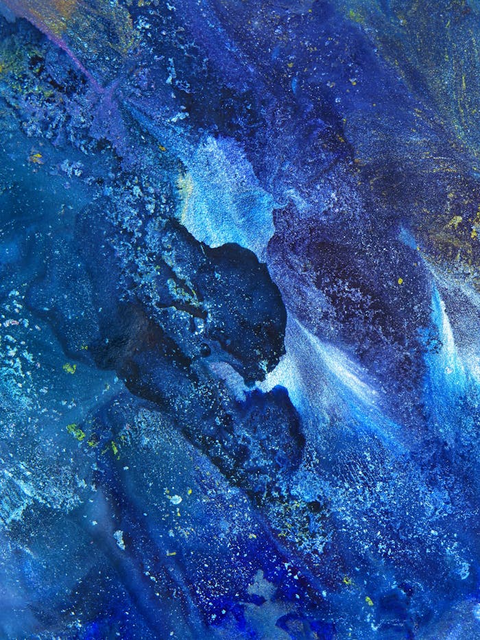 Dynamic and vibrant abstract painting with rich blue hues, showcasing fluid acrylic textures and artistic expression.