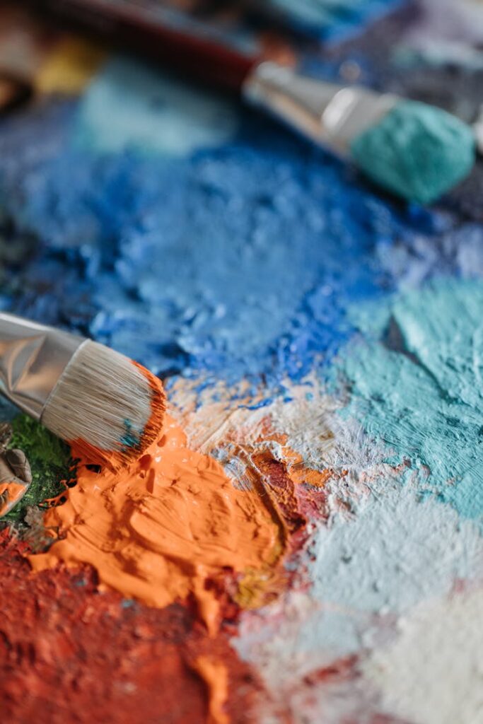 A colorful assortment of paints and brushes in an artistic setup, expressing creativity.